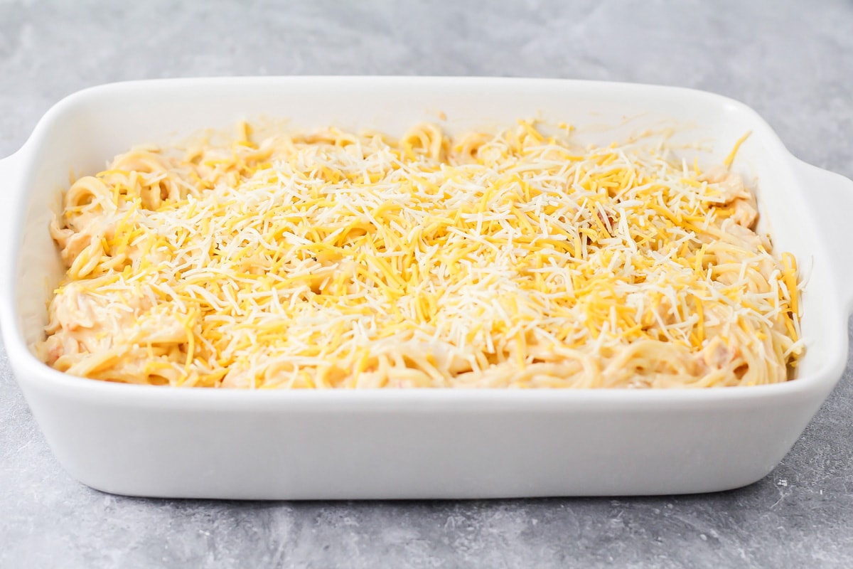Cheese sprinkled over chicken spaghetti recipe.