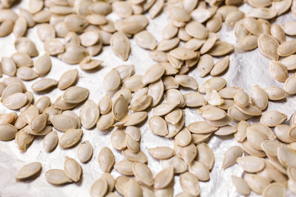 Roast pumpkin seeds on baking sheet lined with foil.