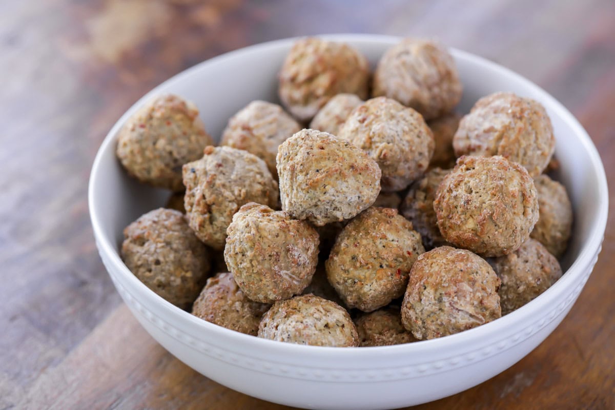 Frozen meatballs in a white bowl.