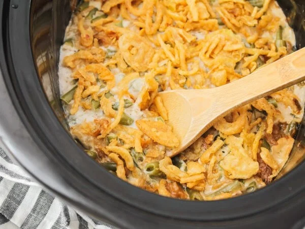 Crockpot green bean casserole in a crock pot topped with crispy fried onions.