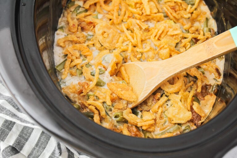 Crockpot green bean casserole in a crock pot topped with crispy fried onions.
