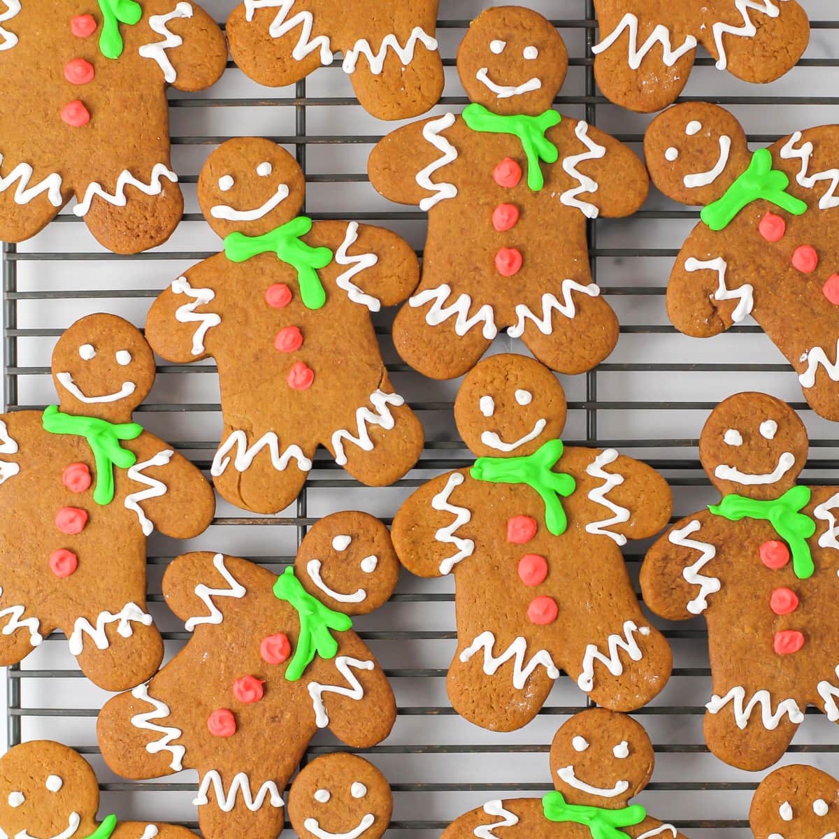 Top view of decorated gingerbread men on a cooling rack.