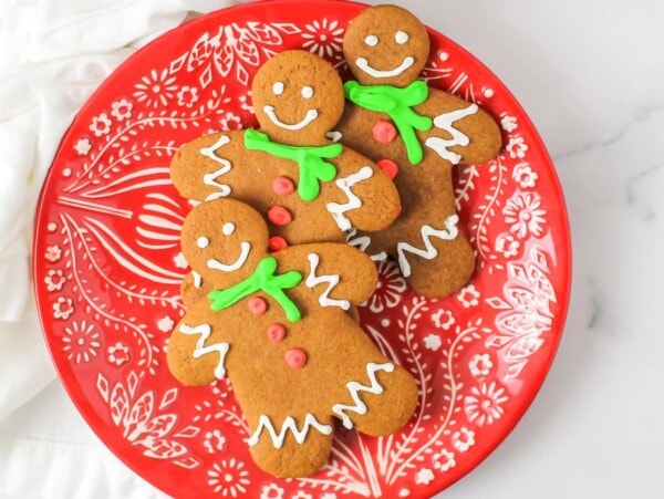 The Best Gingerbread cookie recipe - decorated and stacked on a Christmas plate.