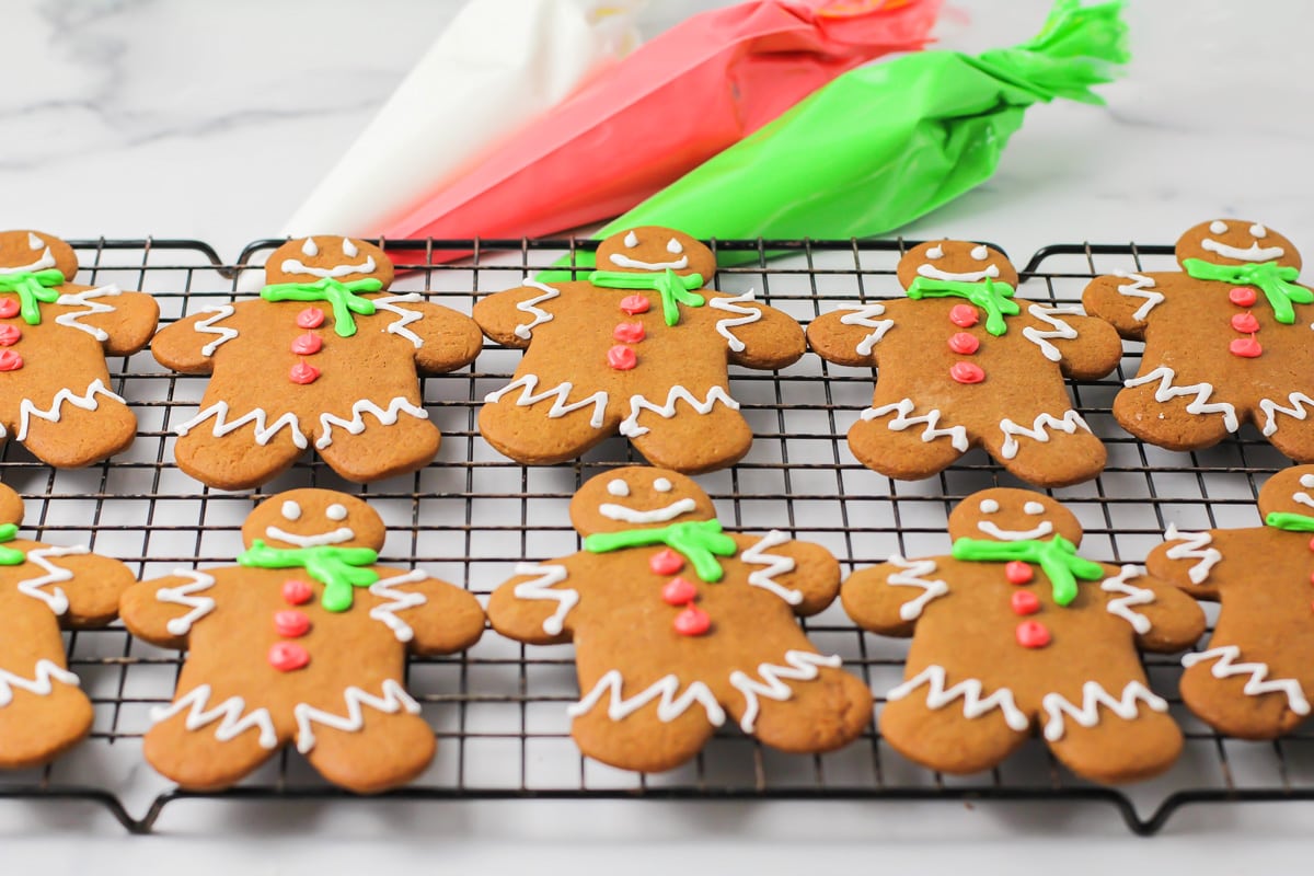 Decorated gingerbread cookies resting on a wire cooling rack.