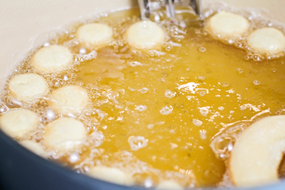 Donut holes being fried in oil.