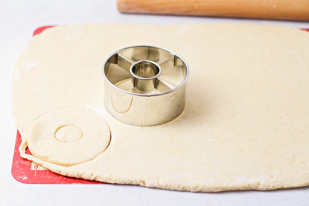 Donuts being cut out of dough.