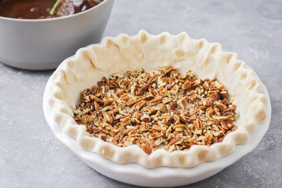 Crunched pecans in the bottom of a pie shell.