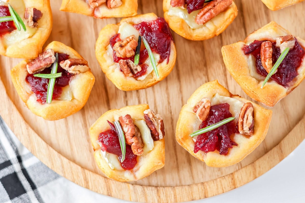 Top view of several cranberry brie bites topped with fresh rosemary.