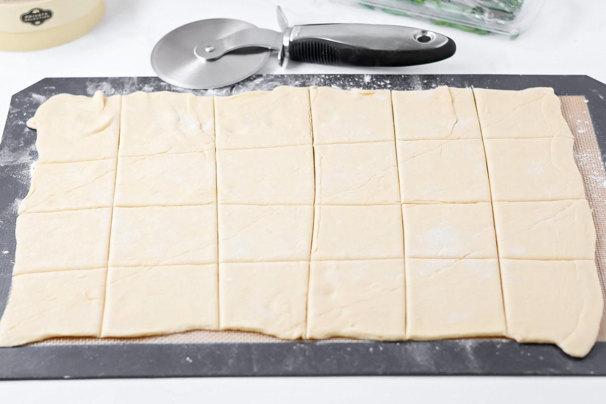 Cutting crescent into squares for cranberry brie bites.