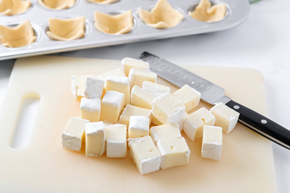 Cutting brie for cranberry brie bites.
