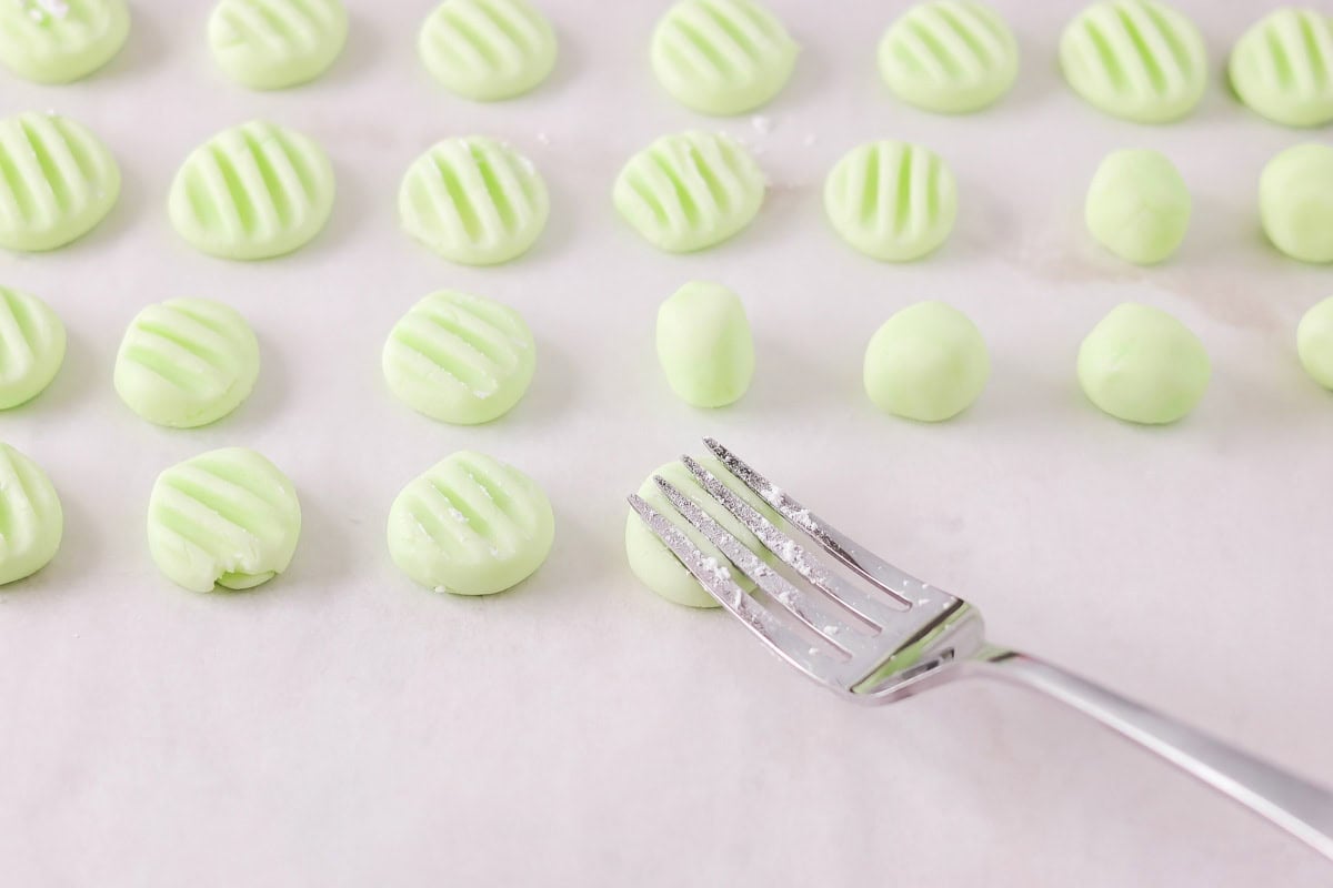 Process picture of how to make cream cheese mints on parchment.