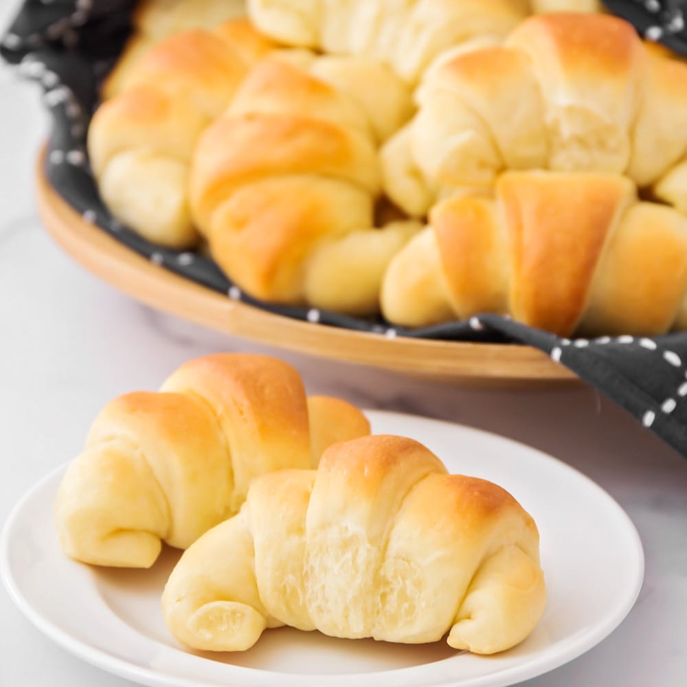 Crescent rolls piled in a wooden bowl.