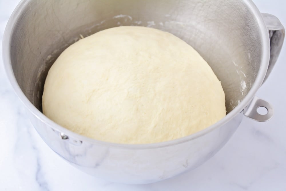 Crescent roll dough rising in a mixing bowl.