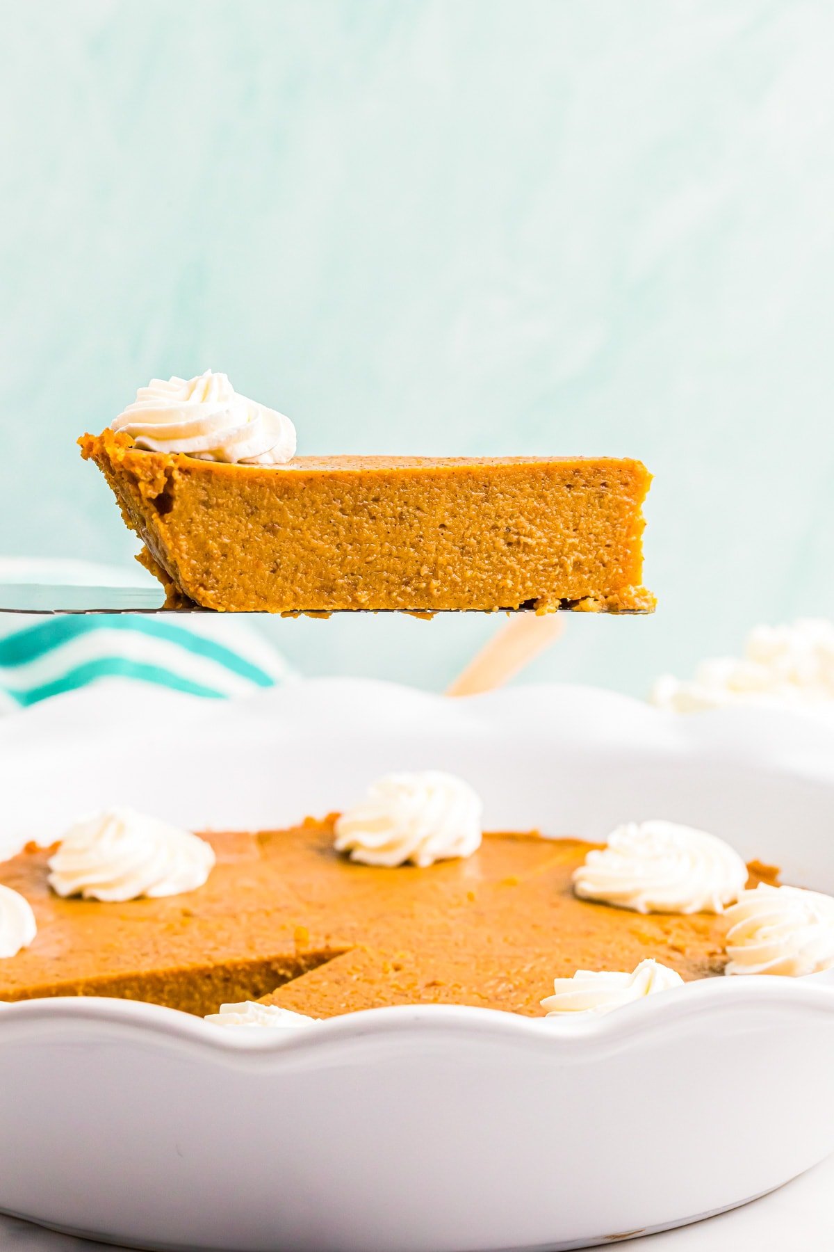 Cutting and removing a slice of crustless pumpkin pie from the pan.