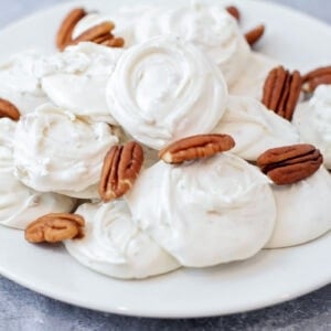 Divinity recipe on a white plate with pecans.