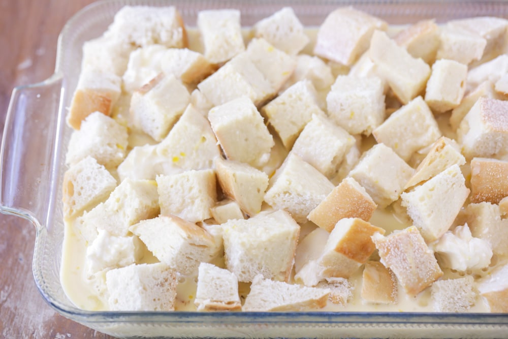 Egg mixture poured over bread cubes in a baking dish.