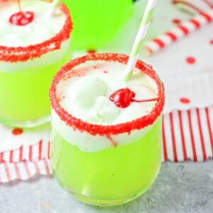 Two red sugar rimmed glasses of grinch punch recipe.