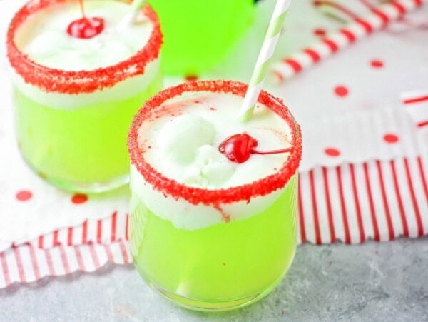 Two red sugar rimmed glasses of grinch punch recipe.