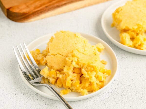 Jiffy Corn Pudding recipe scooped onto white plate.