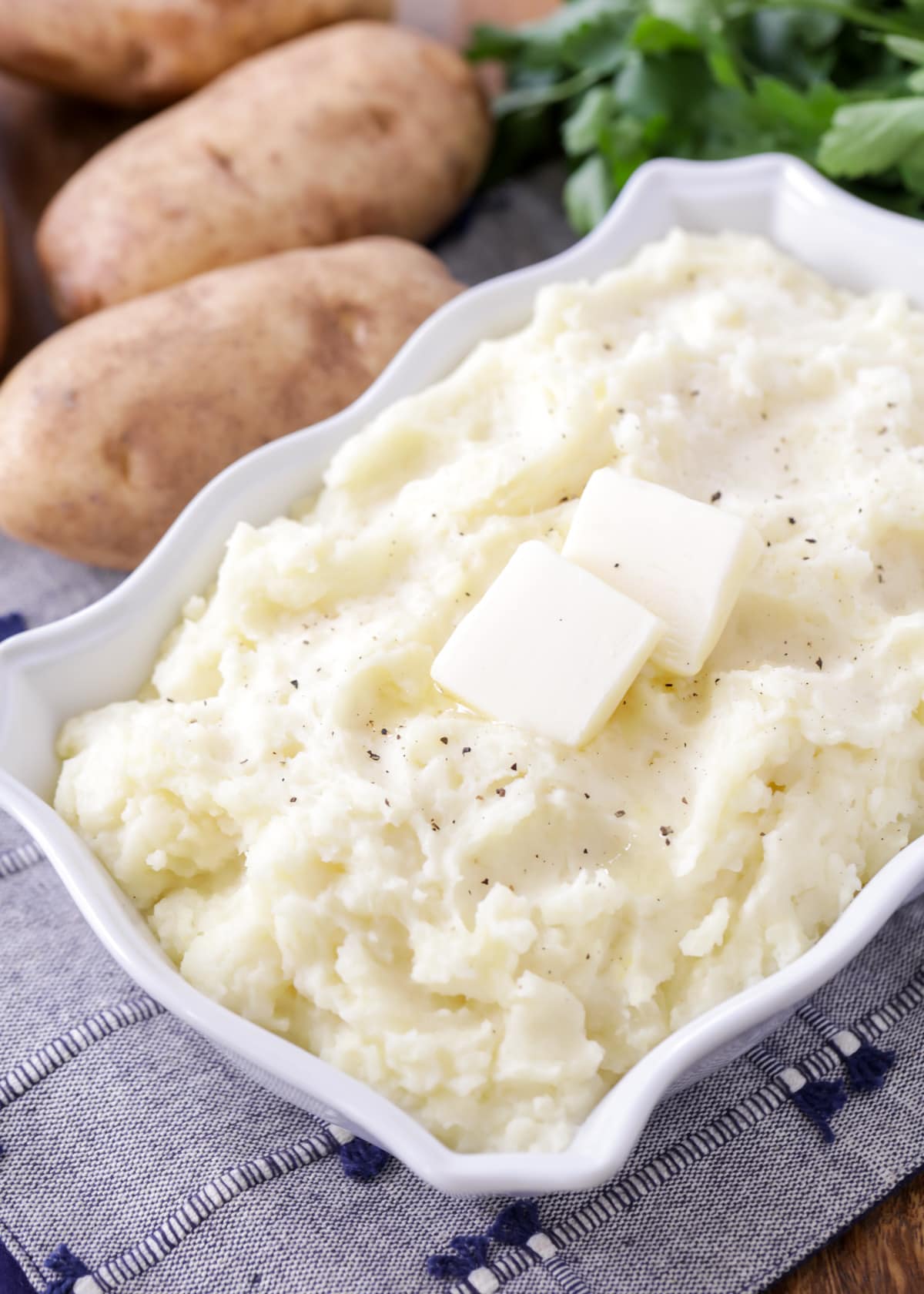 Best mashed potatoes recipe in white dish close up image.