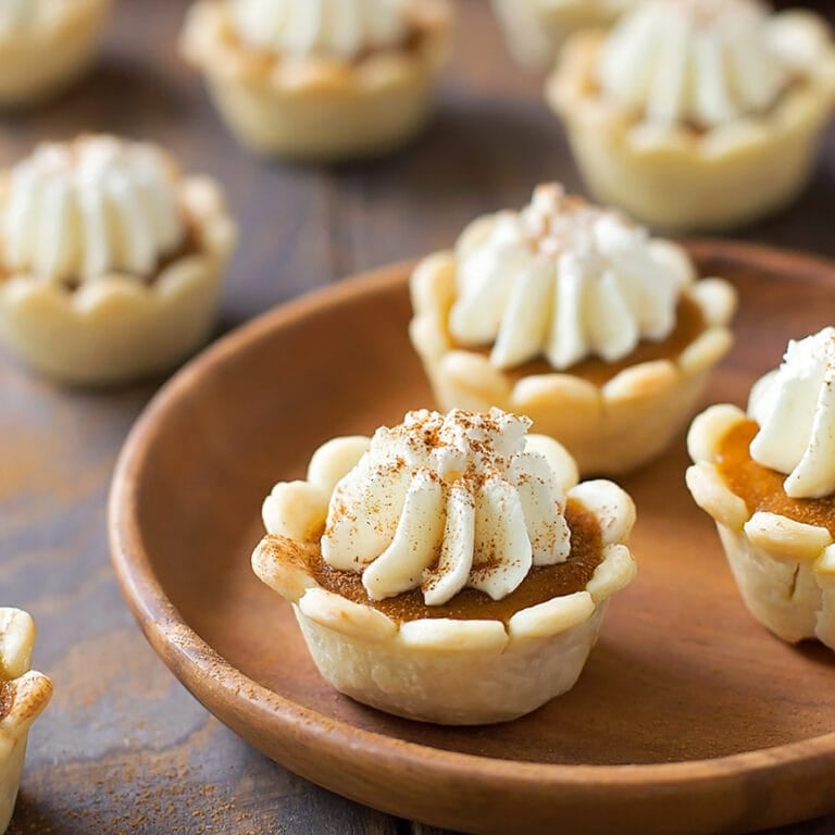 Several mini pumpkin pie bites topped with whipped cream.