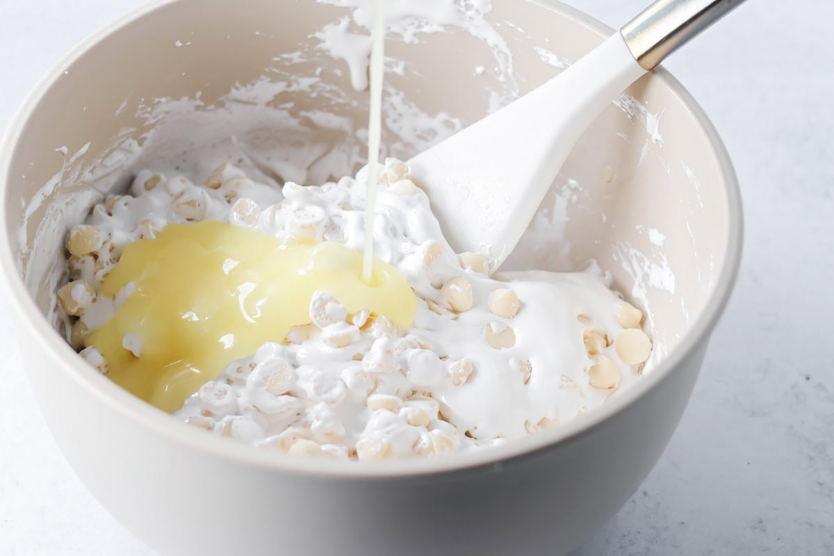 Adding melted butter to white chocolate chips for oreo fudge.