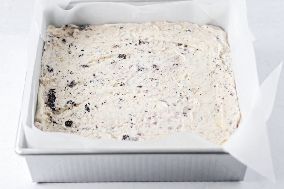 Oreo fudge spread in a lined baking dish.