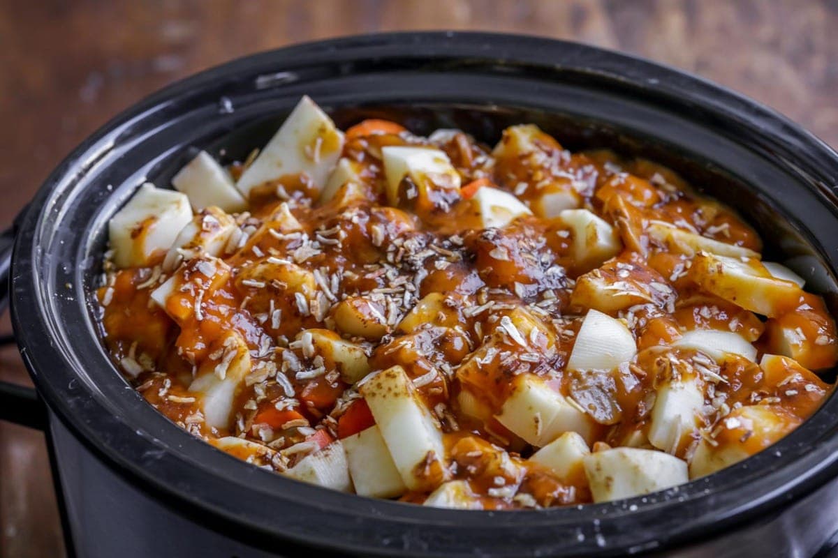 Potatoes, carrots, and beef in a slow cooker for slow cooker beef stew.
