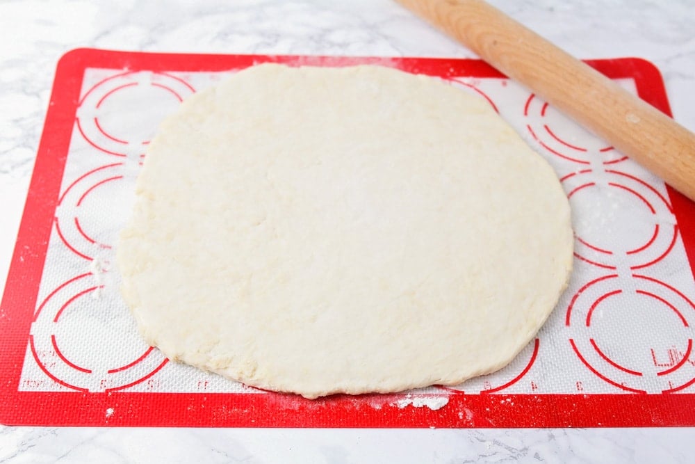 Sopapilla dough rolled out onto a pastry mat.
