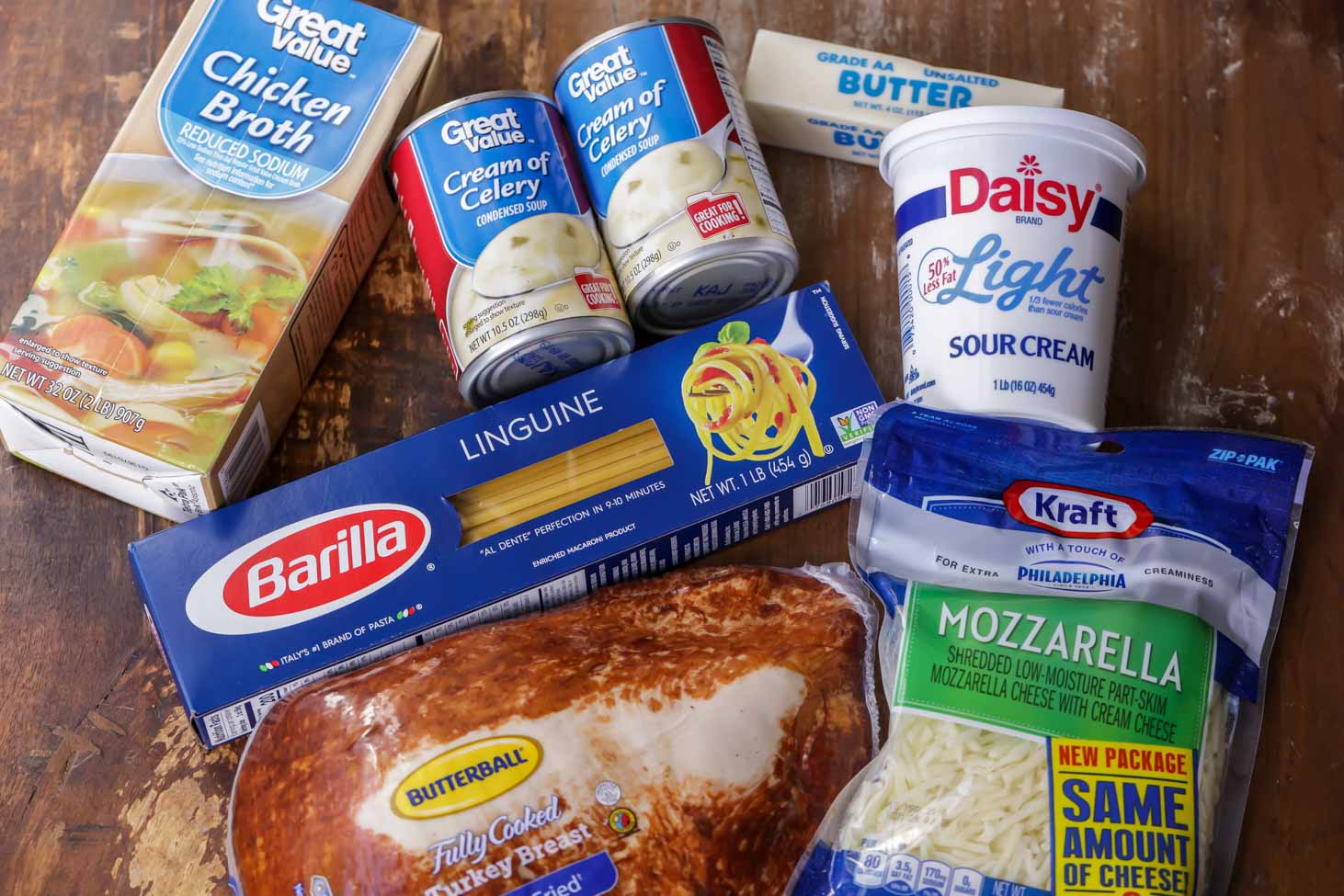 Soup, cheese, sour cream and other ingredients on a counter.