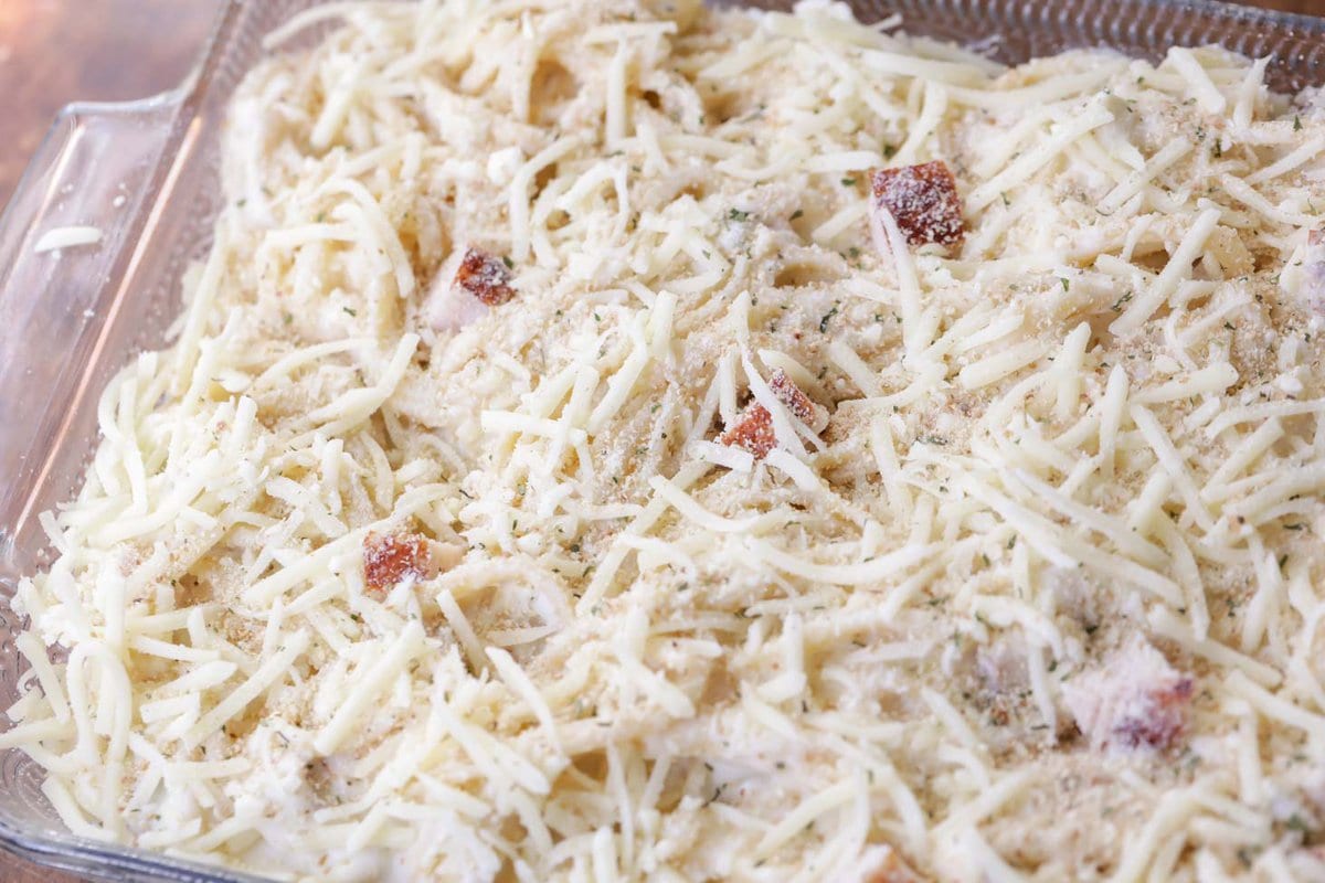 Pasta and turkey topped with shredded cheese in a baking dish.