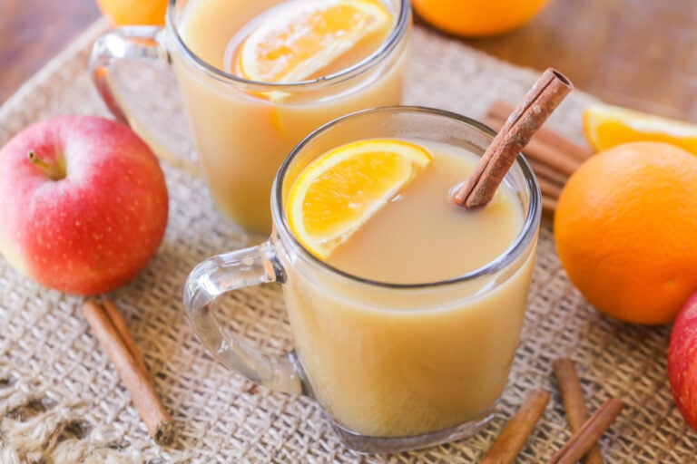 Homemade wassail in a glass mug.