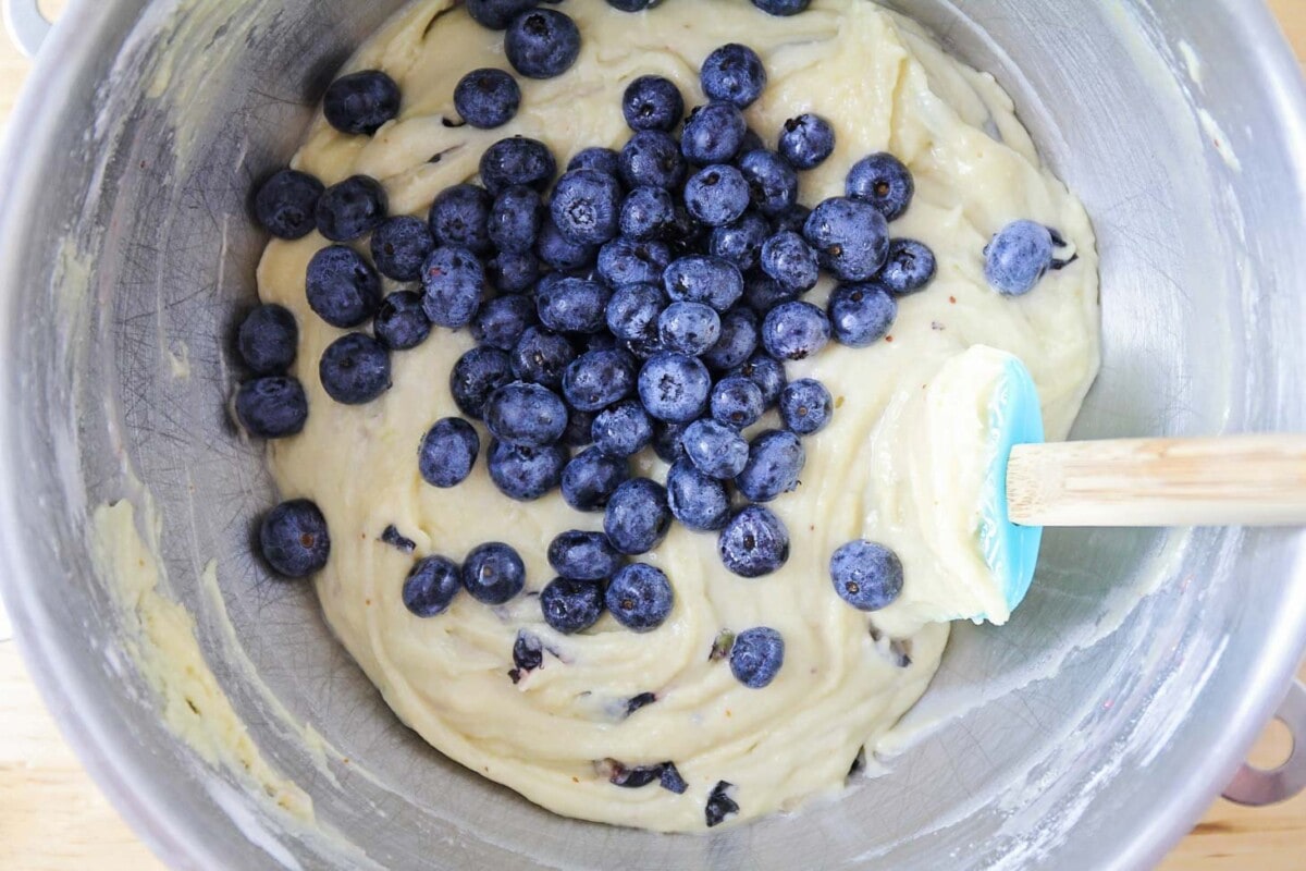 Blueberries being added to a muffin batter.