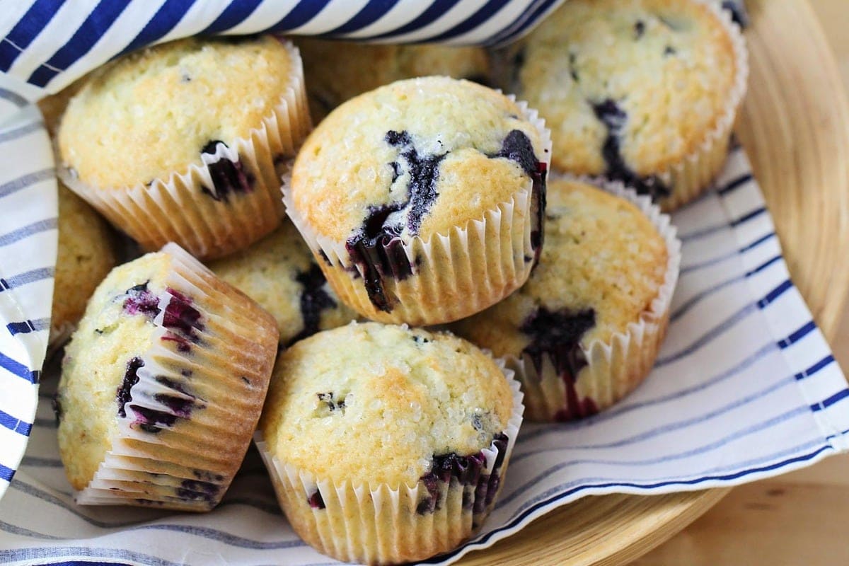 This bowl of blueberry muffin recipe on top of a blue/white towel.
