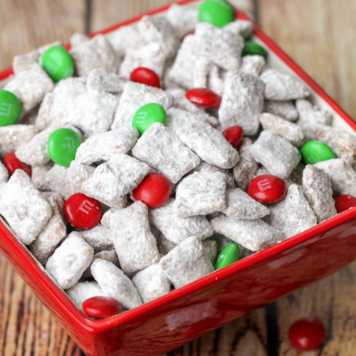 Christmas puppy chow with M&Ms in red bowl.