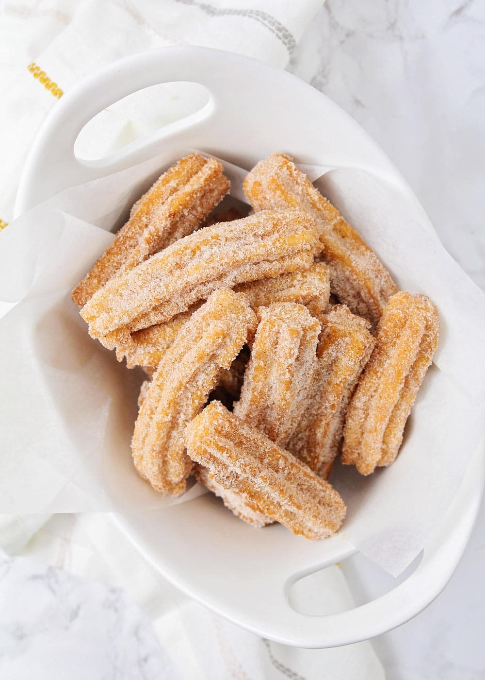Churro recipe stacked together in white dish.