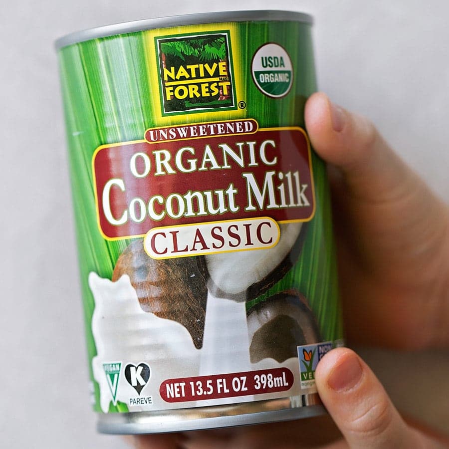 A can of coconut milk held in two hands.