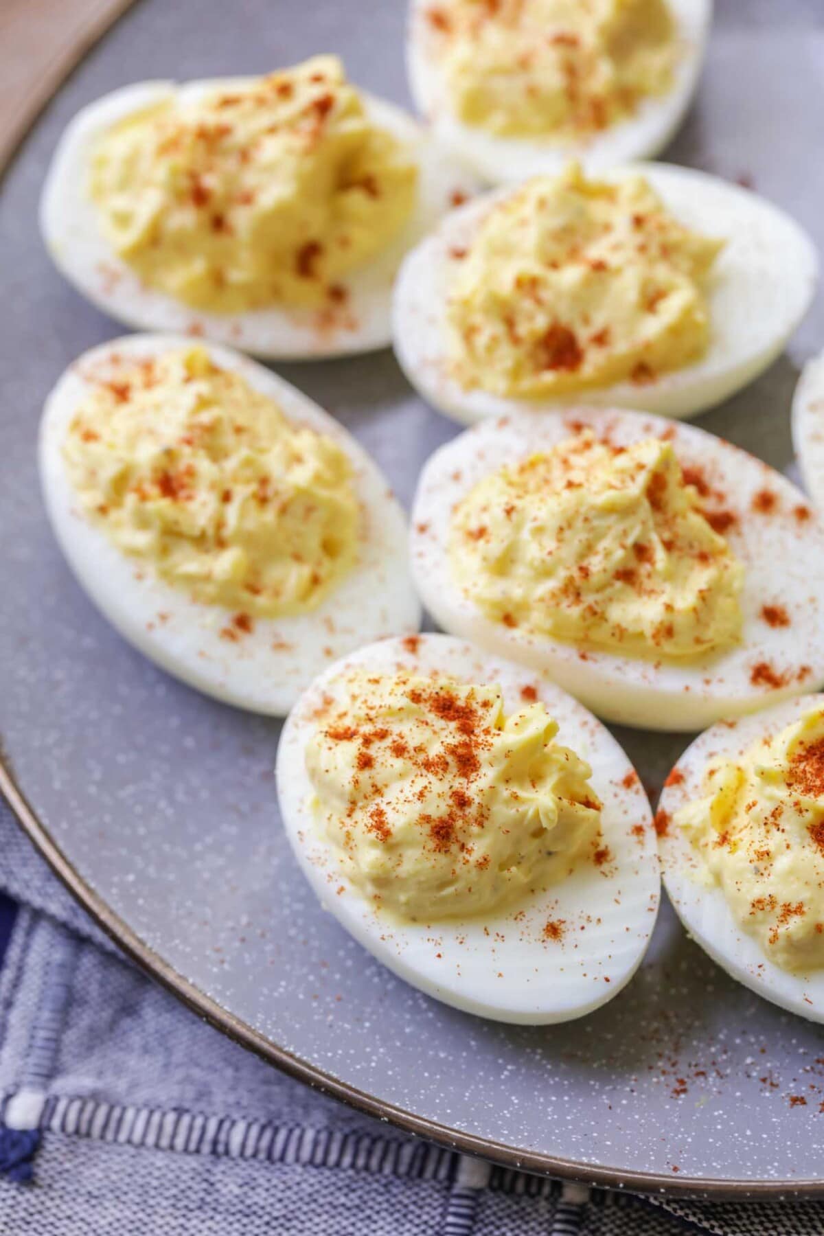 Deviled eggs on a plate topped with paprika.