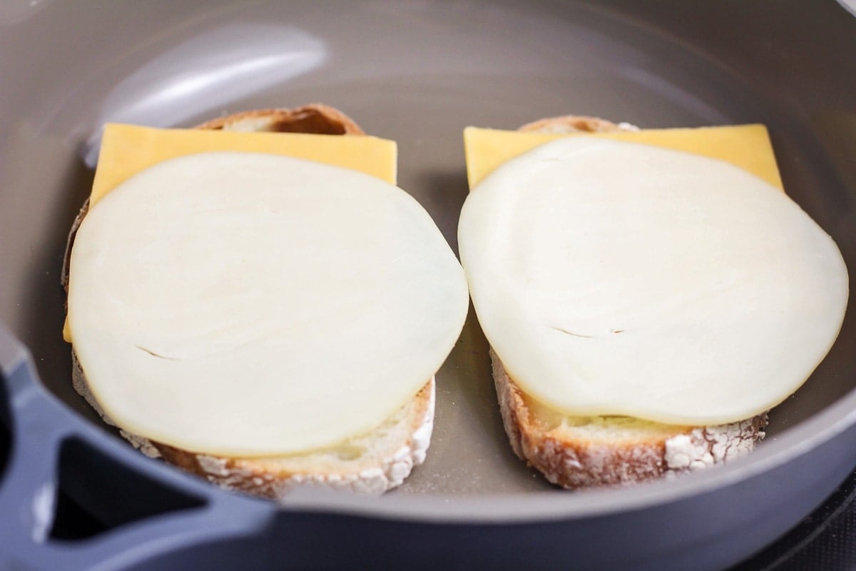Bread and cheese being made into grilled cheese.