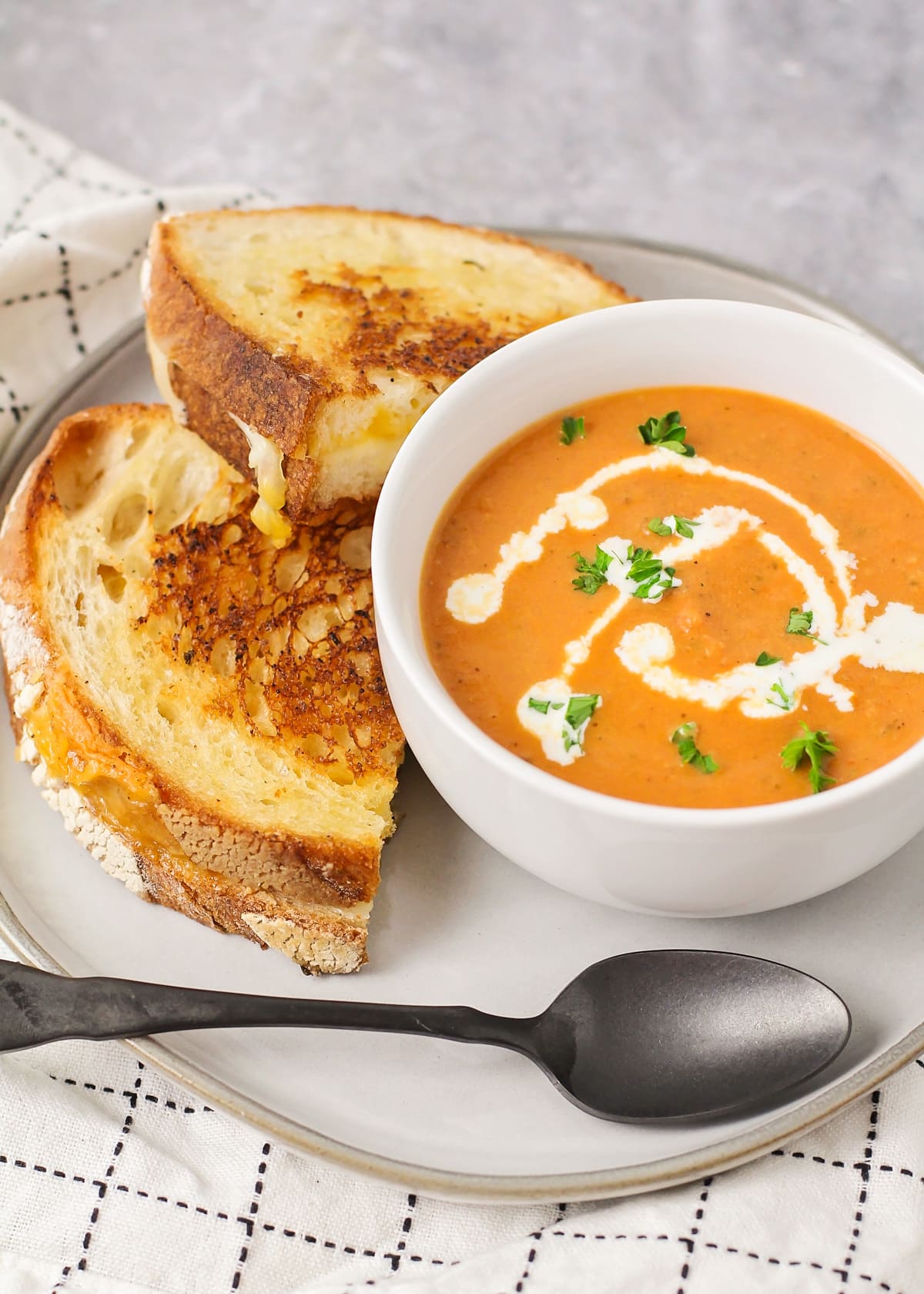 Grilled cheese and tomato soup recipe on plate.