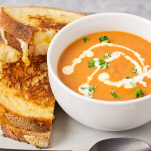 Homemade grilled cheese and tomato soup topped with fresh herbs.