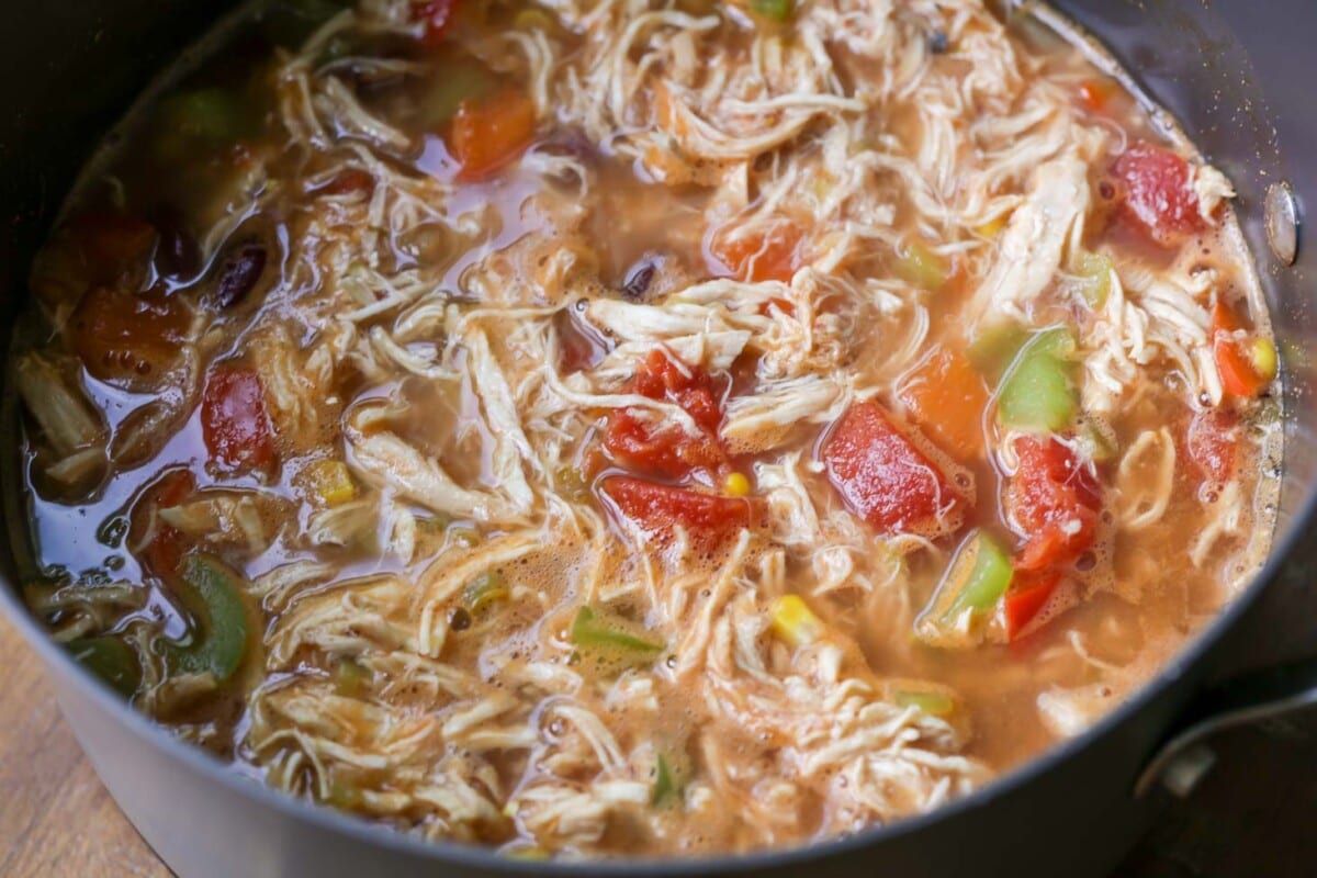 Mexican soup pot filled with shredded chicken, veggies, and broth.