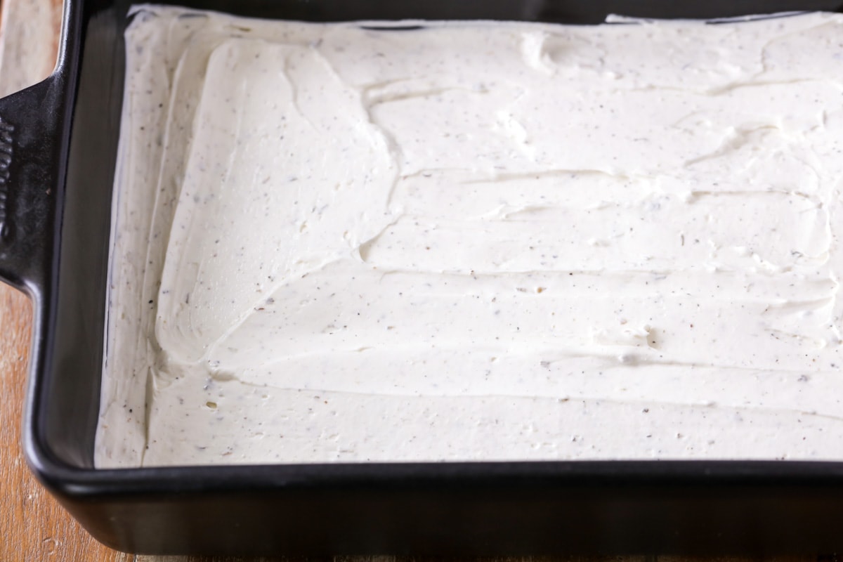 Layering cream cheese mixture in a baking dish.