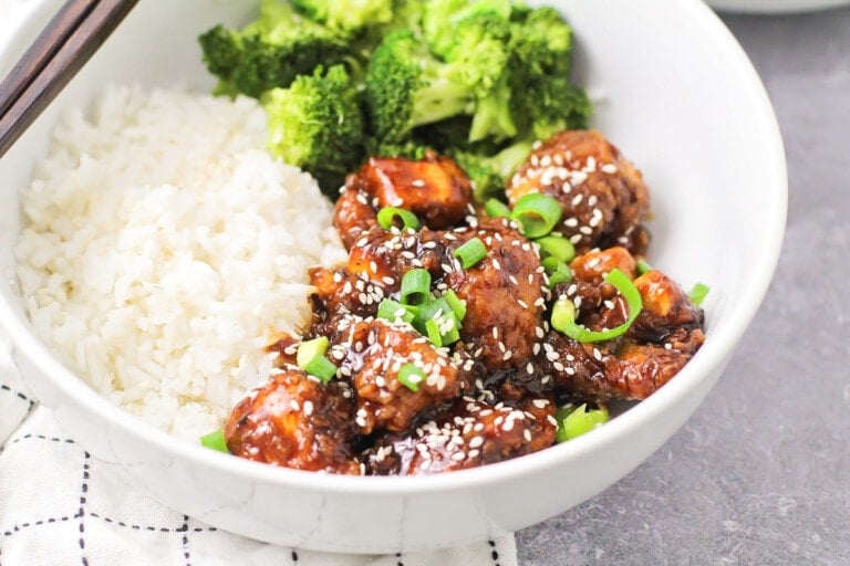 Sesame chicken served in a bowl with white rice.