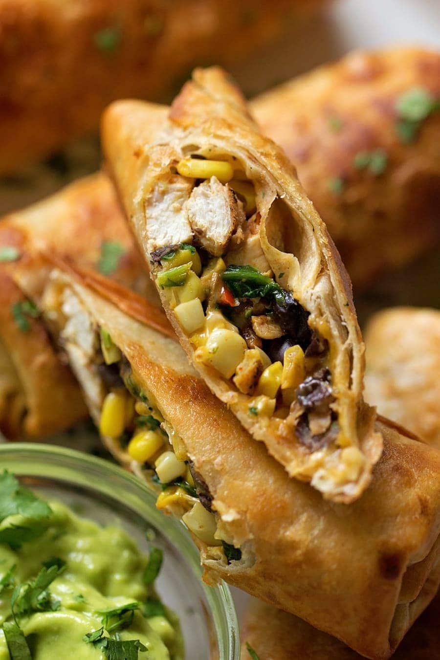 Southwest egg rolls stacked with one cut in half.