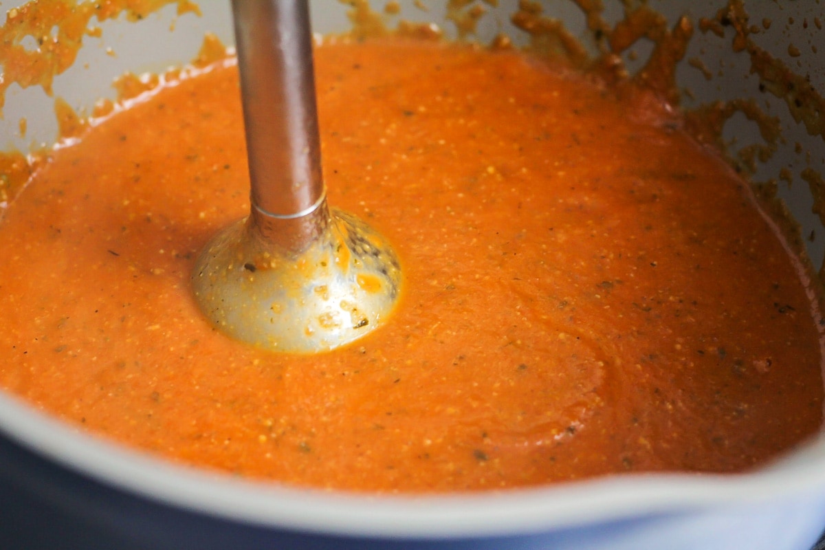 Creamy tomato basil soup in pot.