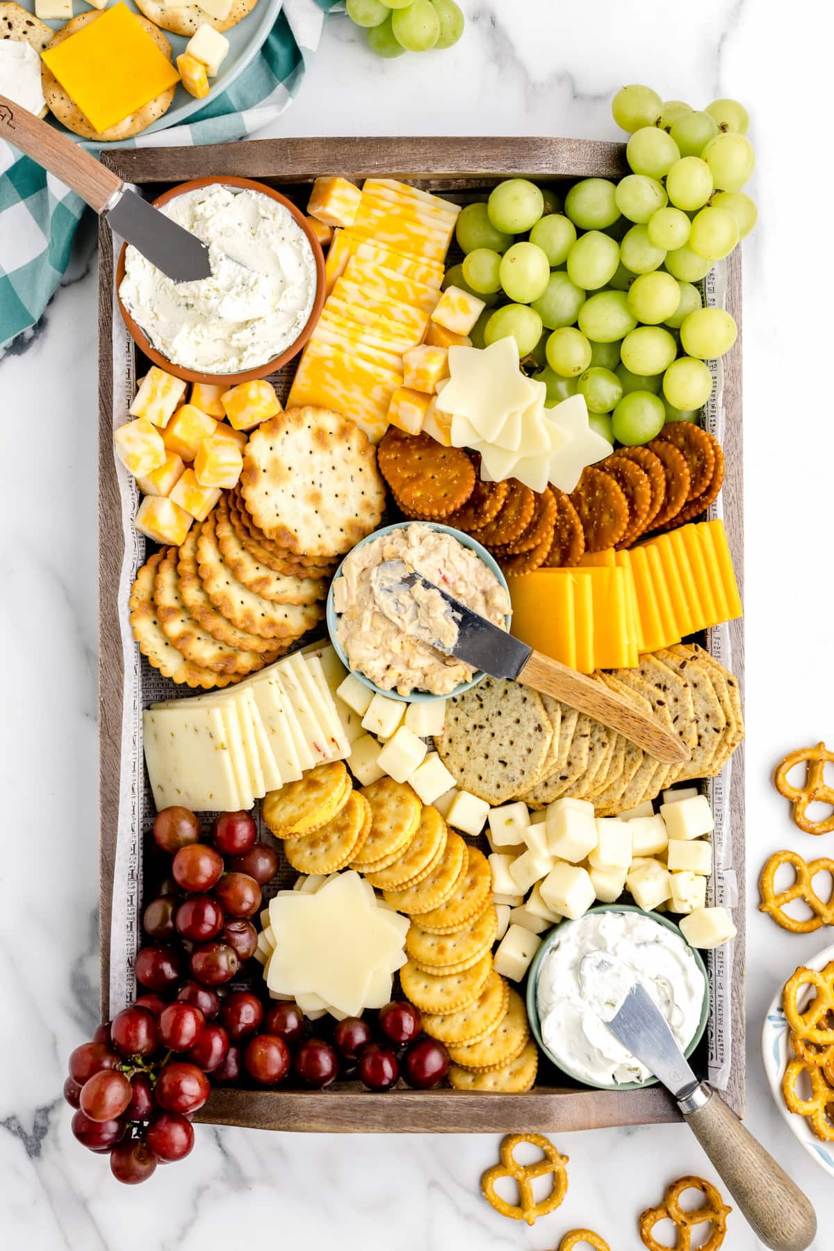 The top view of a cheese and crackers board filled and ready for serving.