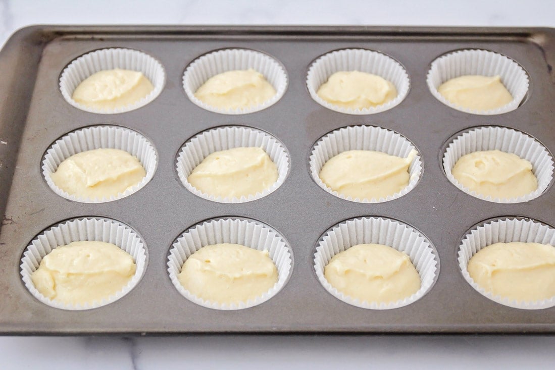 Vanilla cupcake batter in muffin tins.