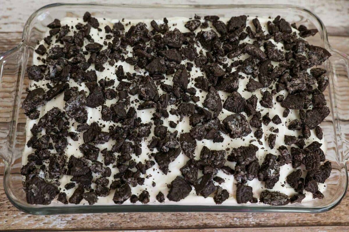 No-bake Easter dirt cake is a super simple creamy favorite packed with Oreo flavor. Everyone will love to decorate and eat it! The final layer of crushed oreos on top of the Easter dirt cake.