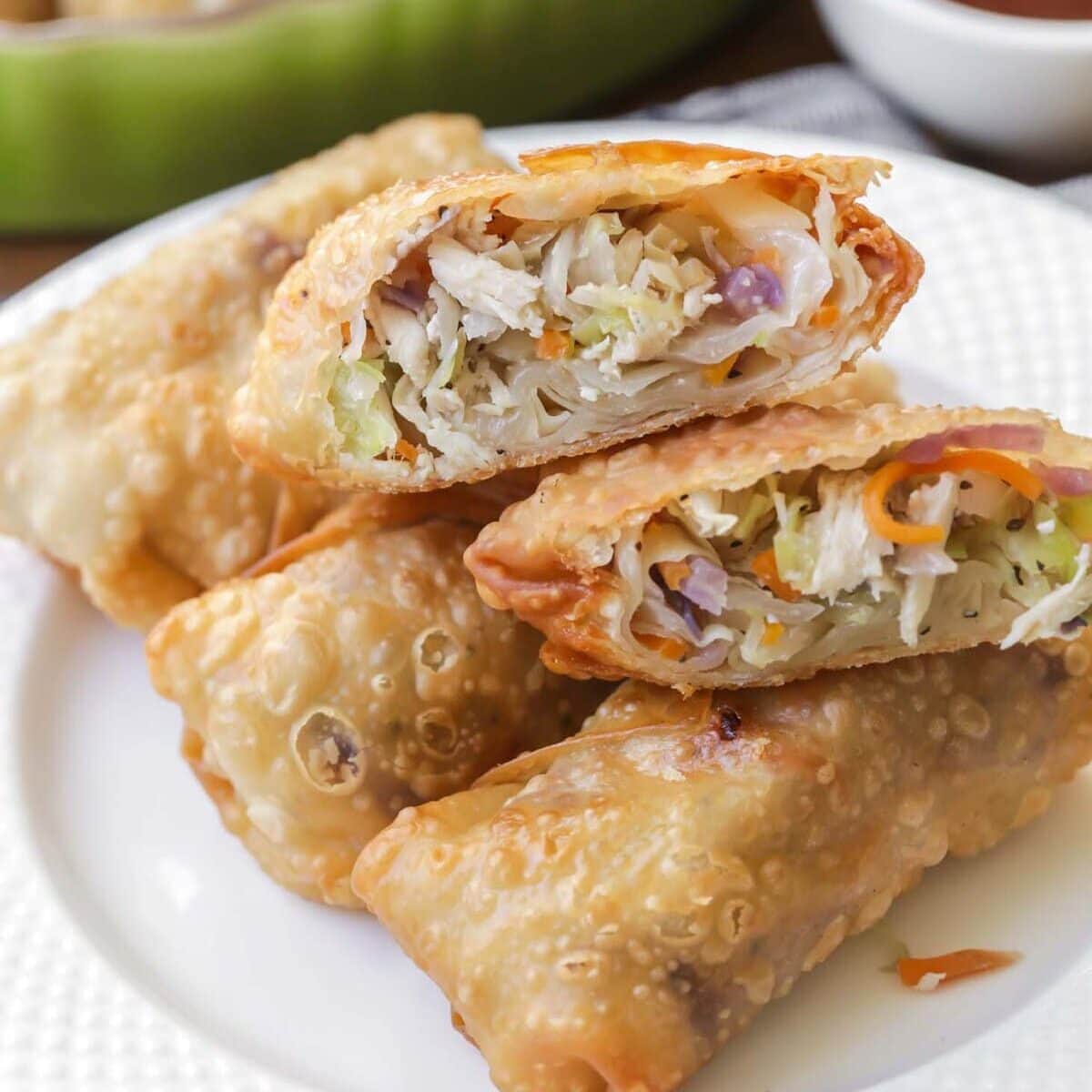 This egg roll recipe cut in half and stacked on a white plate.